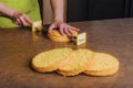 Female baker slicing traditional sponge cake into layers using special cake knife. DIY, sequence, step by step.