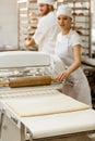 female baker using industrial dough roller