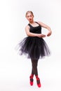 Female ballerina posing in white tutu and ballet shoes on white background. Royalty Free Stock Photo