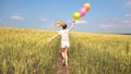 Female with balloons having fun in field in slowmo