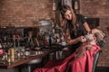 Female barber shaving a client in a barber shop