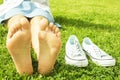 Female bare feet on mawed lawn grass. Young woman resting outdoors barefoot, take a break concept. Student on college campus yard. Royalty Free Stock Photo