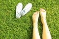 Female bare feet on mawed lawn grass. Young woman resting outdoors barefoot, take a break concept. Student on college campus yard. Royalty Free Stock Photo