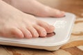 Female bare feet stand on smart scales that makes bioelectric impedance analysis, BIA, body fat measurement. Close-up. Royalty Free Stock Photo