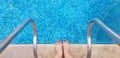 Female bare feet standing on the edge of swimming pool half ready to enter
