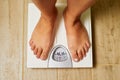 Female bare feet on weight scale in a bathroom Royalty Free Stock Photo