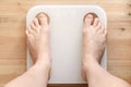 Female bare, hairy legs stand on smart scales that makes bioelectric impedance analysis, BIA, body fat measurement. Body Royalty Free Stock Photo