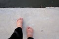 Female barefoot standing on hard cement pathway Royalty Free Stock Photo