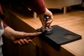 Female barista presses ground coffee using tamper. Close-up view on hands with portafilter