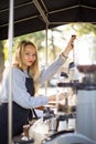 Female barrista making coffee for clients