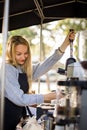 Female barrista making coffee for clients