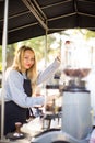 Female barrista making coffee for clients