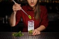 Female bartender adding a leaf of fresh mint to a cane sugar wit Royalty Free Stock Photo