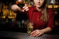 Female bartender adding a liquor from the bottle to the cocktail Royalty Free Stock Photo