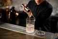 Bartender pours drink from jigger to glass Royalty Free Stock Photo