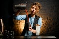 Female bartender carefully pours tomato juice to metal cup Royalty Free Stock Photo