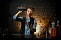 Female bartender expertly pours tomato juice in metal cups