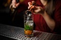 Female bartender pouring out a transparent alcoholic drink from Royalty Free Stock Photo