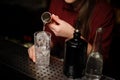 Female bartender pouring some gin into a cocktail glass Royalty Free Stock Photo