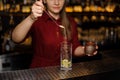 Female bartender pourring into a glass a spoon of cane sugar Royalty Free Stock Photo