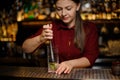 Female bartender pressing down a cane sugar with lime in a glass Royalty Free Stock Photo
