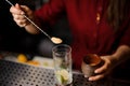 Female bartender putting a spoon of cane sugar into a glass Royalty Free Stock Photo