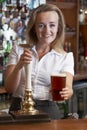 Female Bartender Serving Drink To Customer