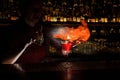 Female bartender spraying on the fire match above the cocktail o