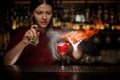 Female bartender spraying on a fire match above the cocktail