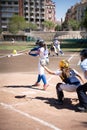 A female batter at the right moment what hits the ball and the catcher behind tries to catch it in a baseball game in the Turia