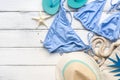 Female beach accessories-bikini swimsuit, hat, flip flops, bag on a white wooden background. Summer vacation concept. Top view, Royalty Free Stock Photo