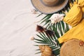 Female beach accessories: swimsuit, bikini, rattan bag, straw hat, shells, sunglasses, palm leaves on sand background Royalty Free Stock Photo