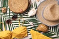 Female beach accessories: swimsuit, bikini, rattan bag, straw hat, shells, sunglasses, palm leaves on sand background Royalty Free Stock Photo