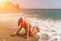 Female beach Santa hat wave coast. beach relaxation seaside. A woman in a red swimsuit enjoying her time on the beach Royalty Free Stock Photo