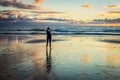 Female on beach takes Picture of sunset with Cell