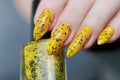 Female beautiful hand with long nails and a yellow nail polish Royalty Free Stock Photo