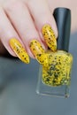 Female beautiful hand with long nails and a yellow nail polish Royalty Free Stock Photo