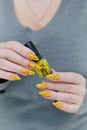 Female beautiful hand with long nails and a yellow nail polish Royalty Free Stock Photo