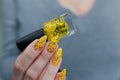 Female beautiful hand with long nails and a yellow nail polish Royalty Free Stock Photo
