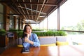 Female beautiful student sitting at cafe with smartphone and notebook on table.