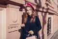 Female beauty, fashion. Stylish woman wearing pink beret holding purse outdoors. Spring clothes, accessories Royalty Free Stock Photo