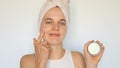 Female beauty routine. Moisturizing cream jar. Clean and smooth skin. Spa skincare regimen. Cute young woman applying cream on her