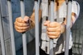 A female behind bars on a jail cell incarcerated Royalty Free Stock Photo