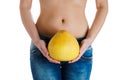 Female belly. Woman Hands holding pomelo. IVF, pregnancy, diet concept. Royalty Free Stock Photo