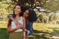 Young african american woman hugging her friend showing love and care in the park - two beautiful women hugging outdoors Royalty Free Stock Photo