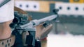 Female biathlete is preparing to shoot from a rifle