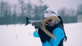 Female biathlete is putting a rifle onto her back after aiming