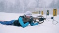Female biathlete is shooting in the middle of a biathlon training