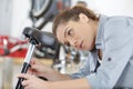 Female bicycle mechanic repairing bike saddle Royalty Free Stock Photo
