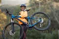 Female biker carrying mountain bike